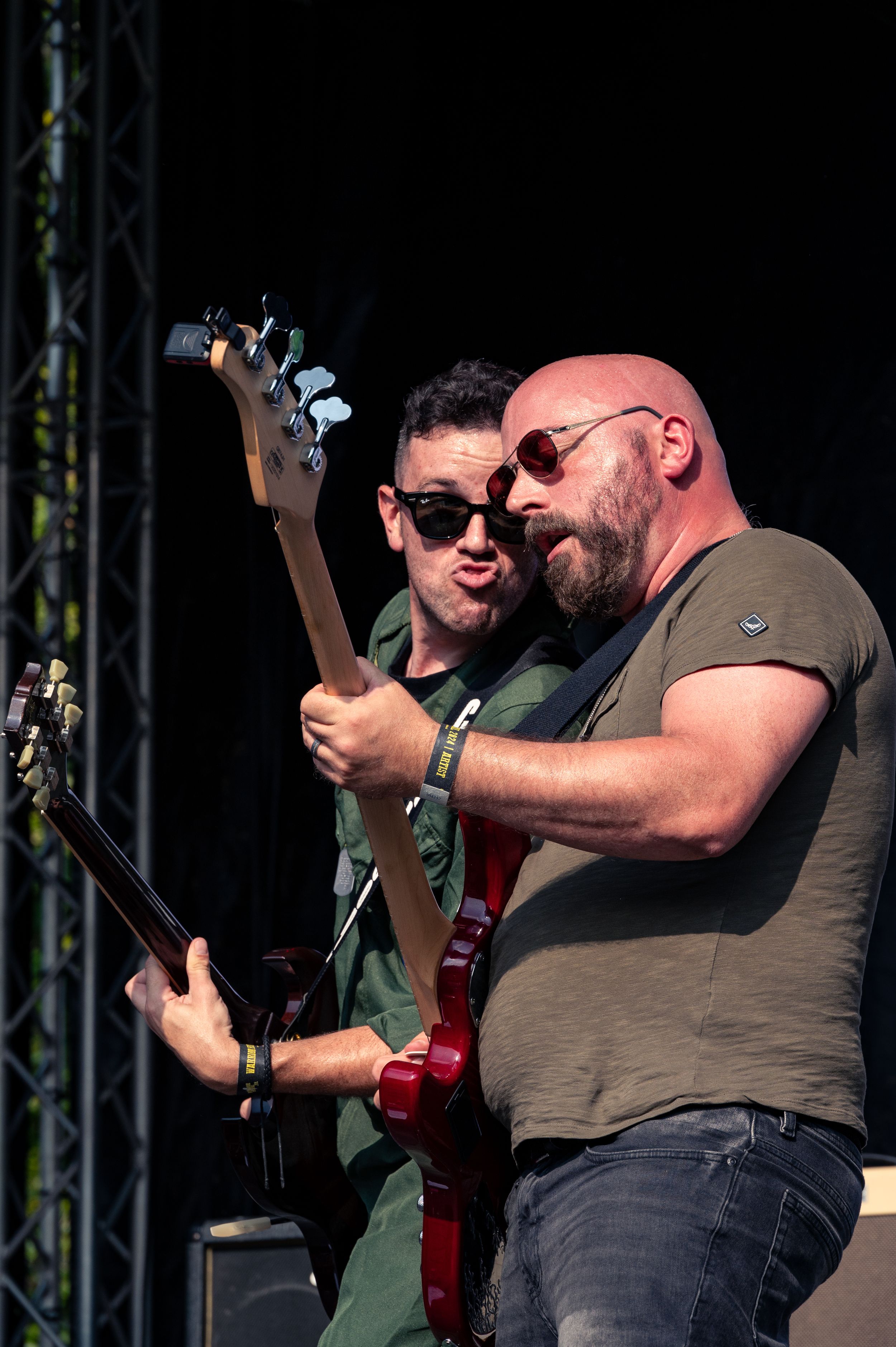 Two musicians performing together on stage with guitars.