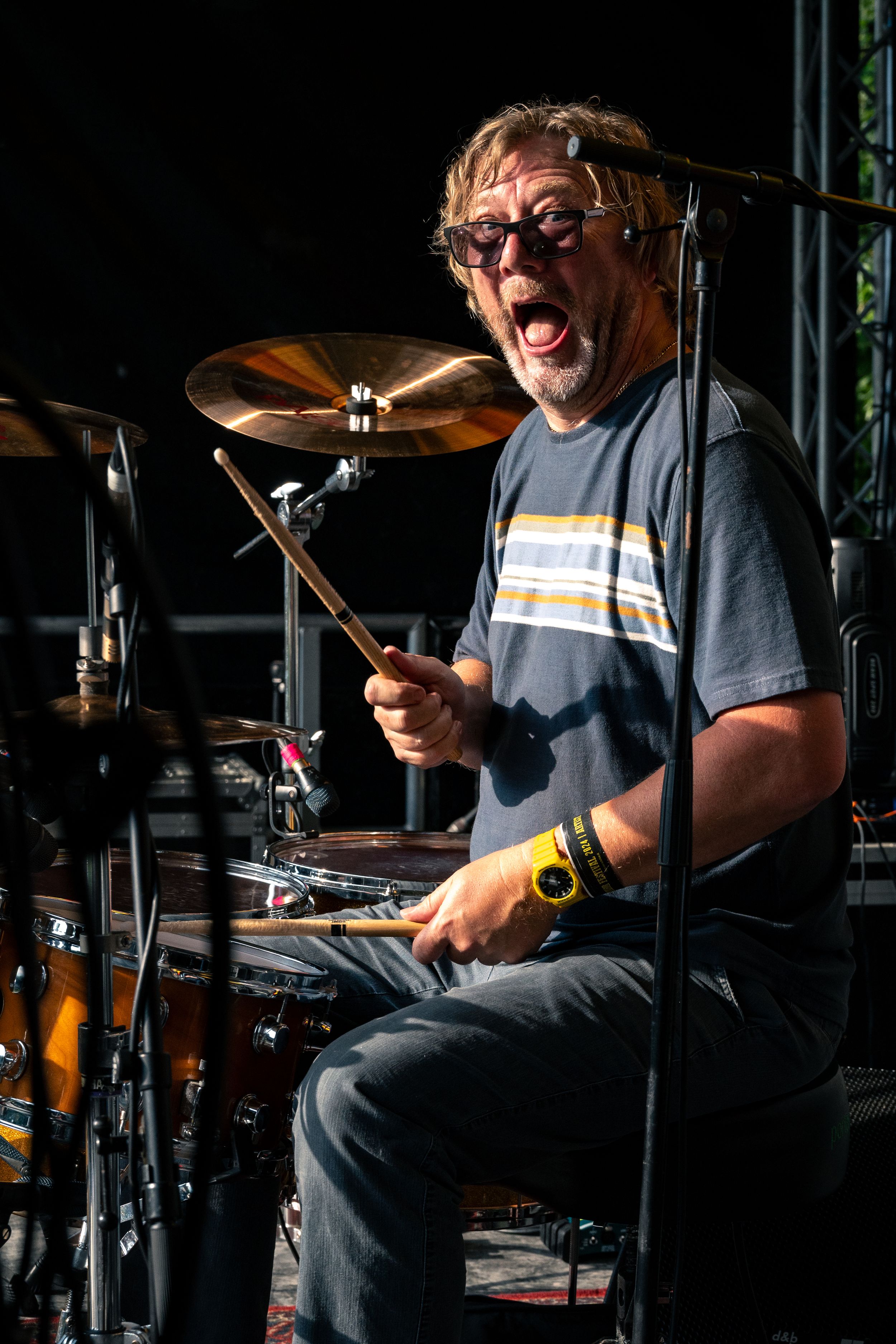 Drummer performs with enthusiasm behind Yamaha kit during daytime festival set.