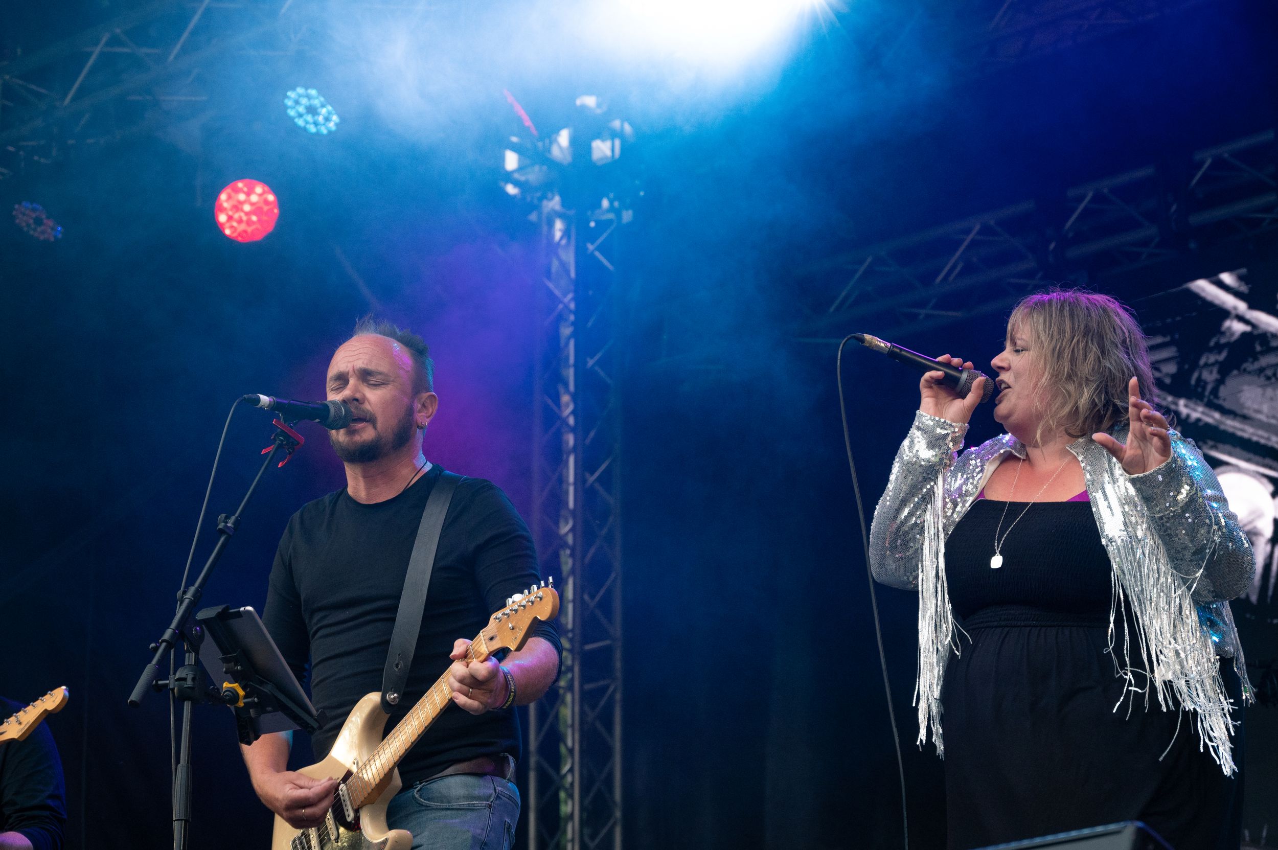 Performers on stage with dramatic blue lighting during a concert performance.