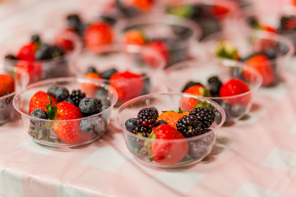 Small glass bowls filled with fresh mixed berries including strawberries and blackberries.