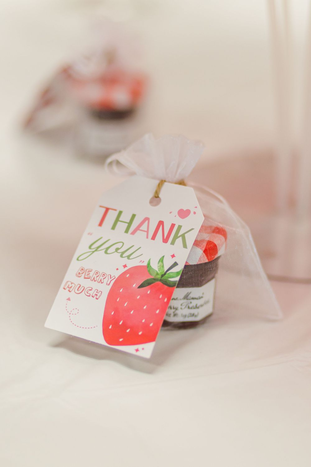 Close-up of a party favor thank you tag with strawberry design.