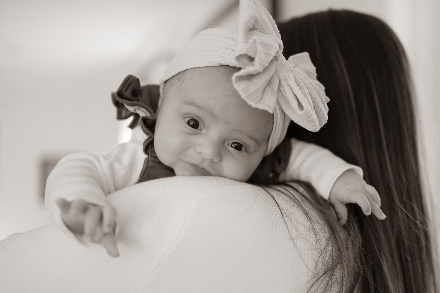 Baby looks over mom's shoulder at in-home lifestyle newborn session in Los Gatos by Cindy Tucey Photography
