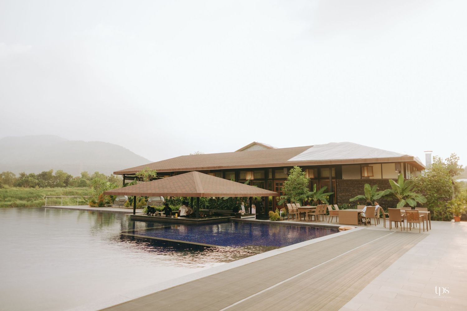 Modern resort building with infinity pool overlooking a scenic mountain landscape.