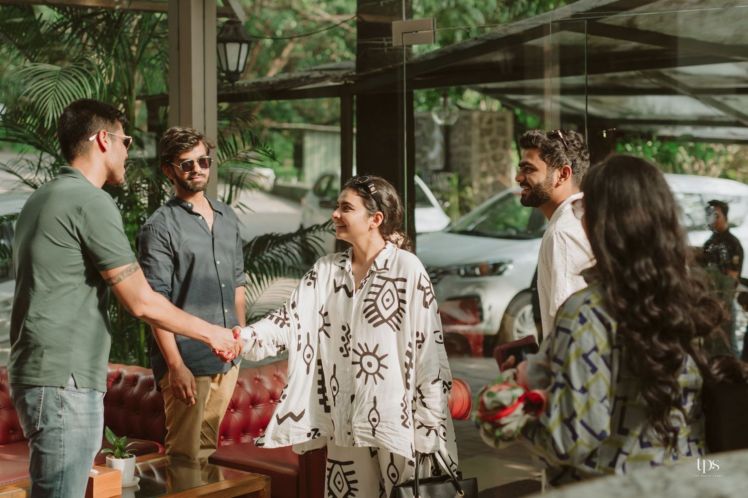 Social gathering in a covered outdoor space with natural lighting and tropical surroundings.