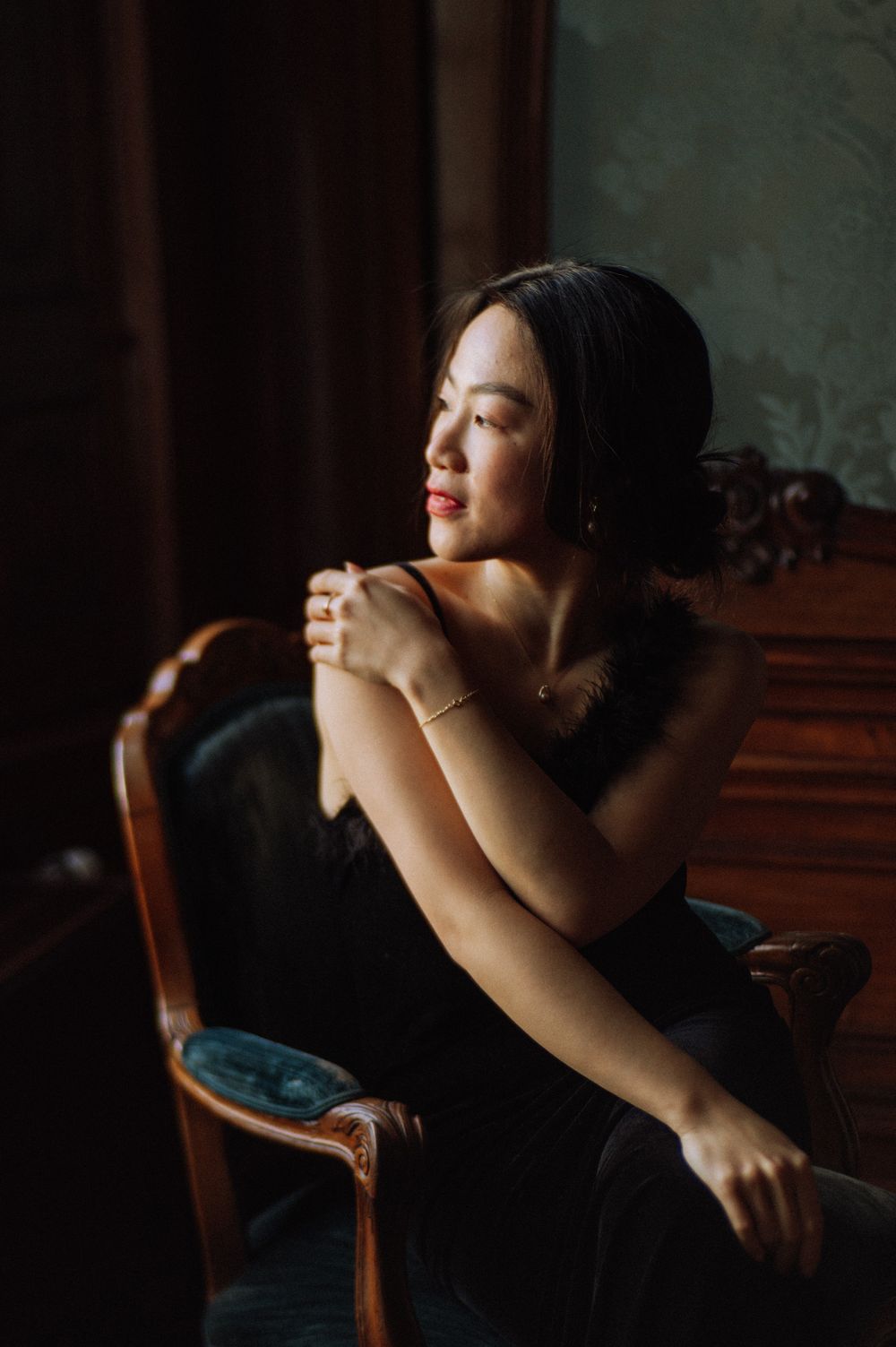Artistic portrait in dark moody lighting with dramatic shadows.