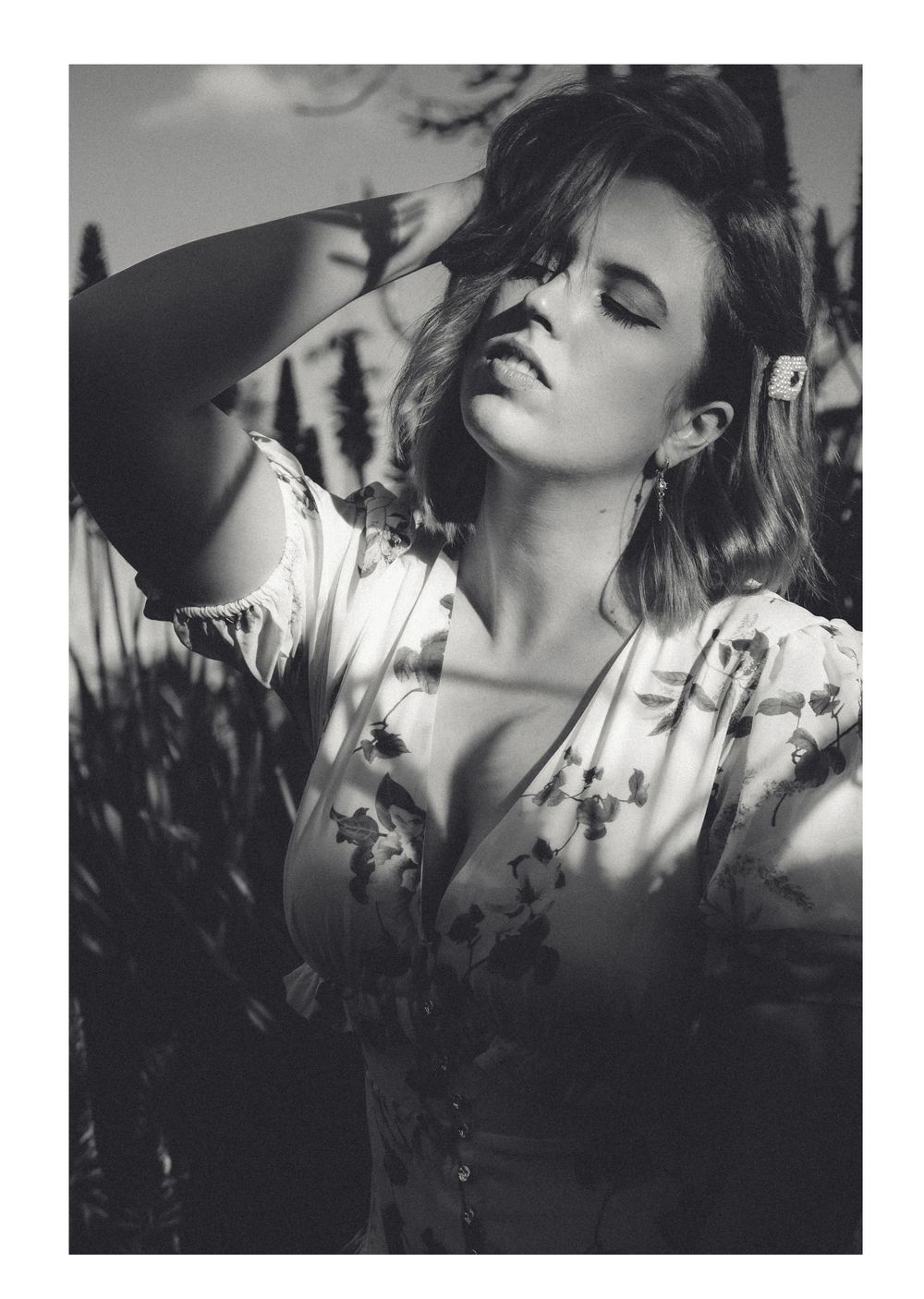 Artistic black and white fashion portrait with dramatic lighting and floral dress.