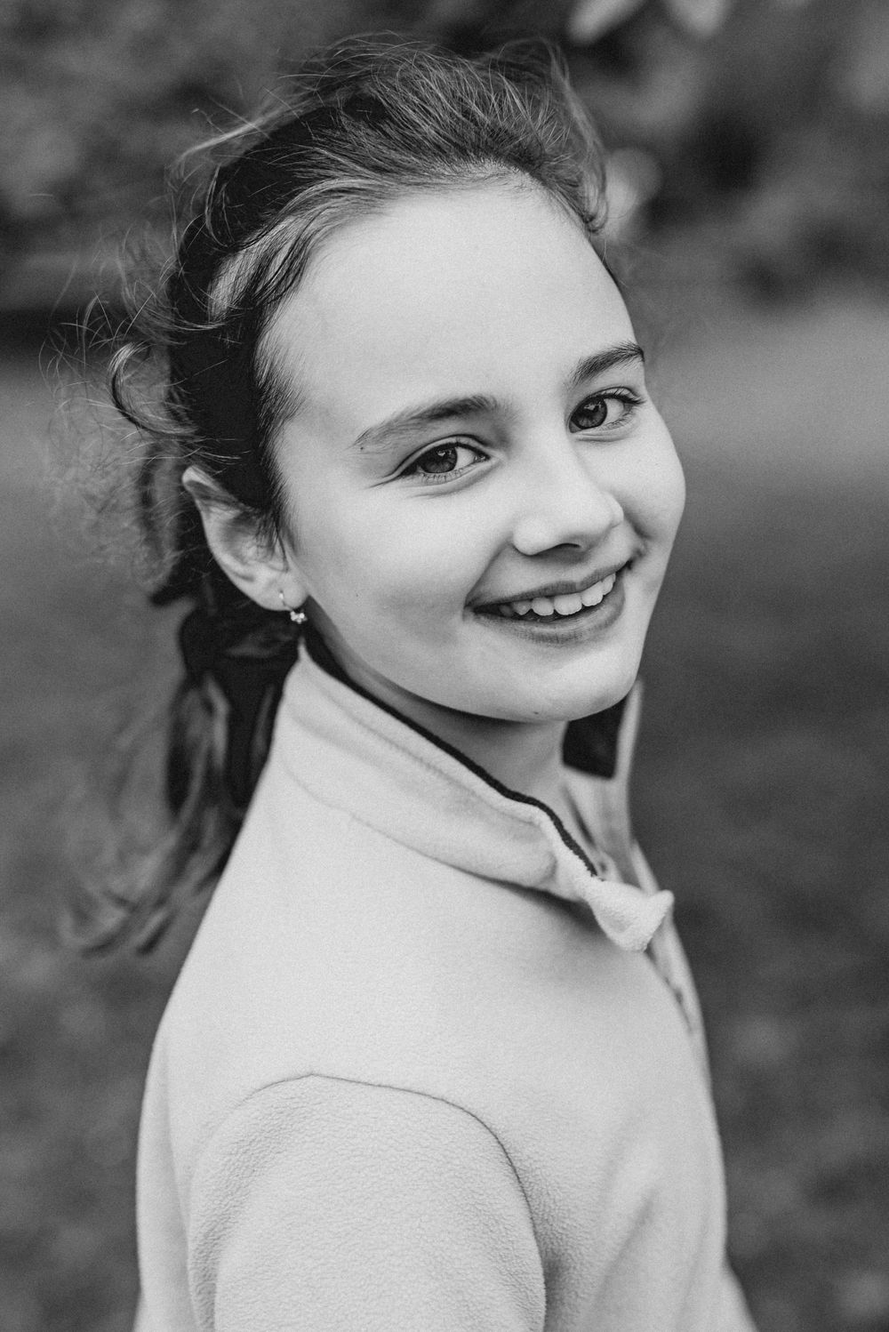 Black and white portrait showing joyful expressions in natural outdoor setting.