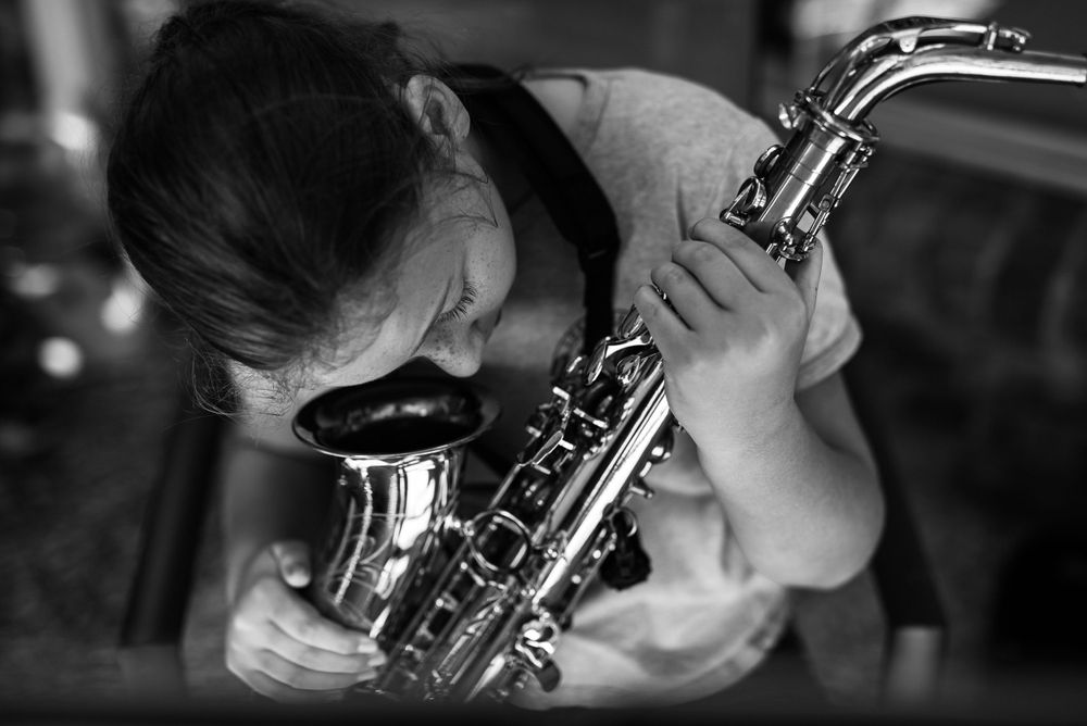 Black and white close-up shots of a person playing a musical instrument.