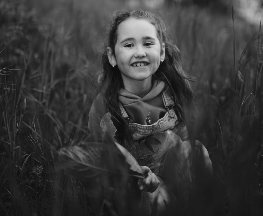 Artistic black and white portraits taken in tall grass with natural lighting.