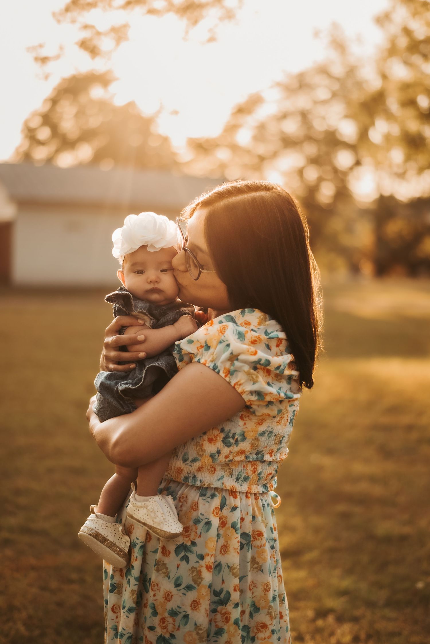 Mother and baby share tender moment during sunset photo session.