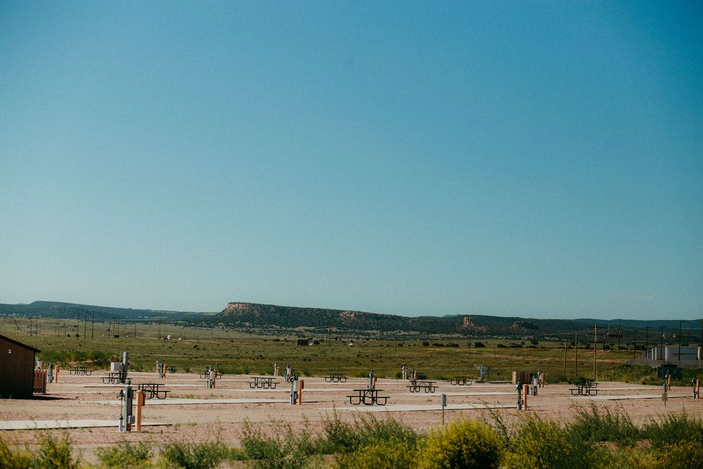 Scenic panoramic view of a beach landscape with people walking along the sandy shore on a clear sunny day.