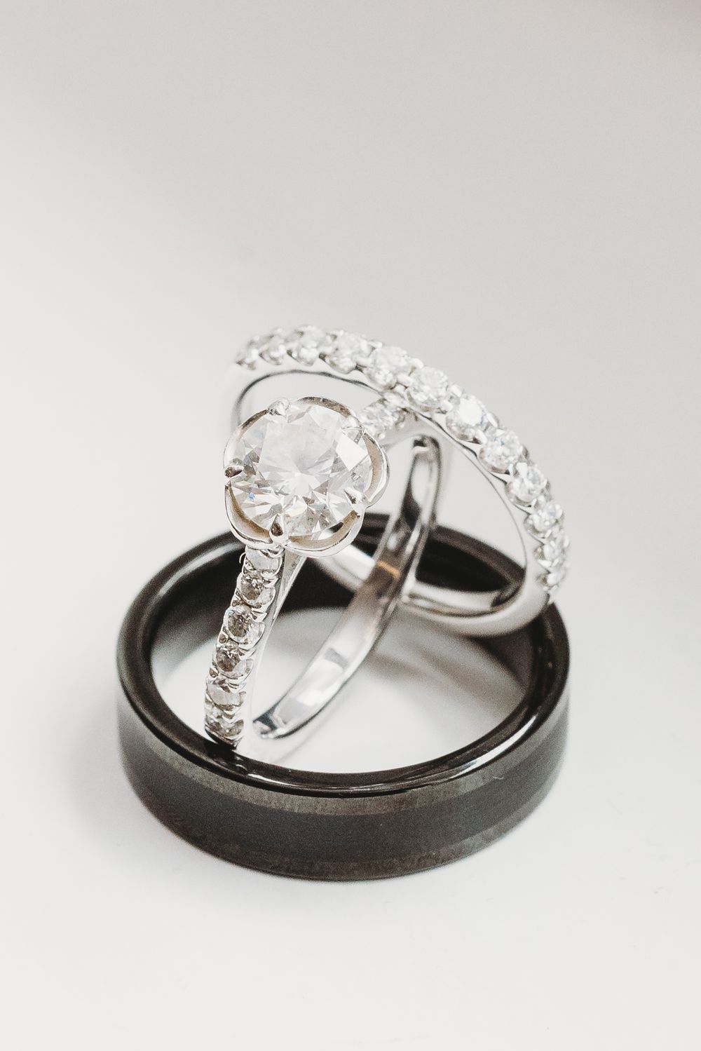 Two elegant wedding rings, one silver and one dark titanium, displayed together in a creative macro photography series.