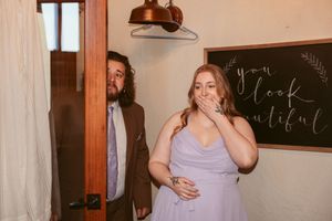 Two people sharing a lighthearted candid moment together in front of a chalkboard wall.