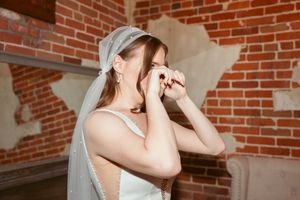 Candid emotional reactions captured during a wedding ceremony in a brick-walled venue.