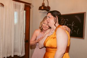 Wedding party members in yellow dresses show emotional reactions during a special moment at the venue.