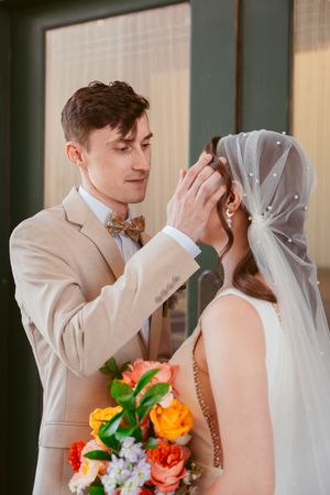 Close-up sequence of emotional first look moments between couple with bright floral bouquet.