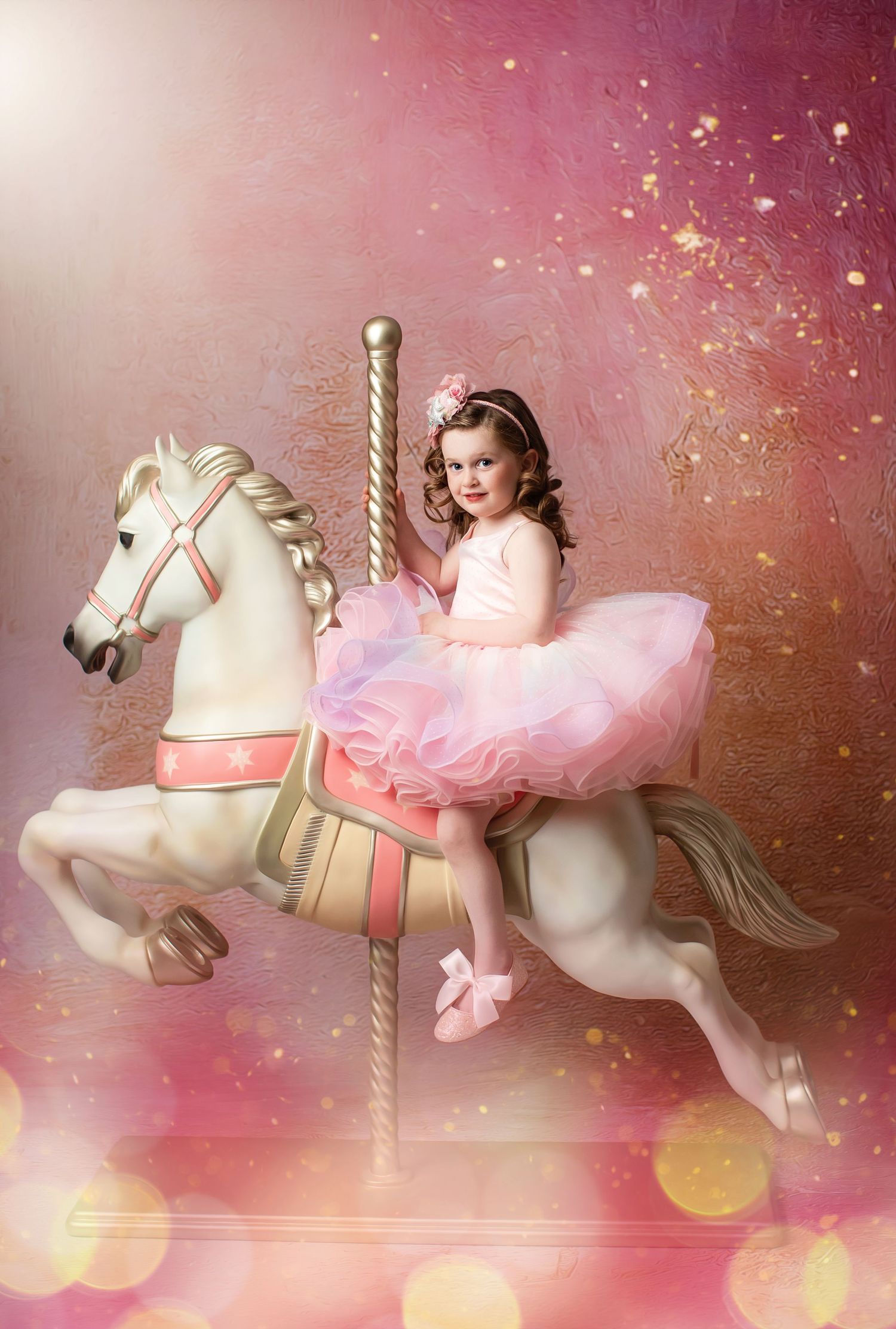 Dreamy carousel scene with white horse against pink sparkly background.