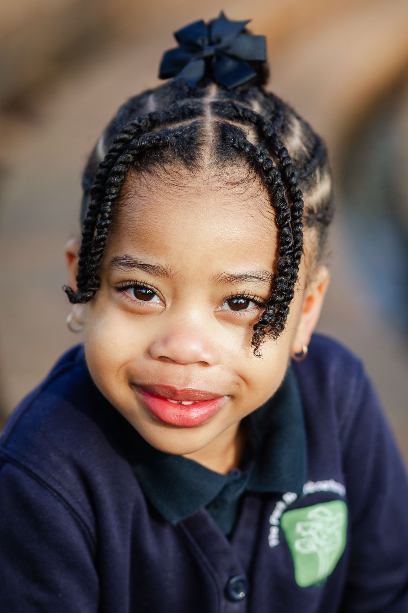 A preschool child smiles and looks at the camera for her school photos. She looks relaxed and natural. Bristol school photography