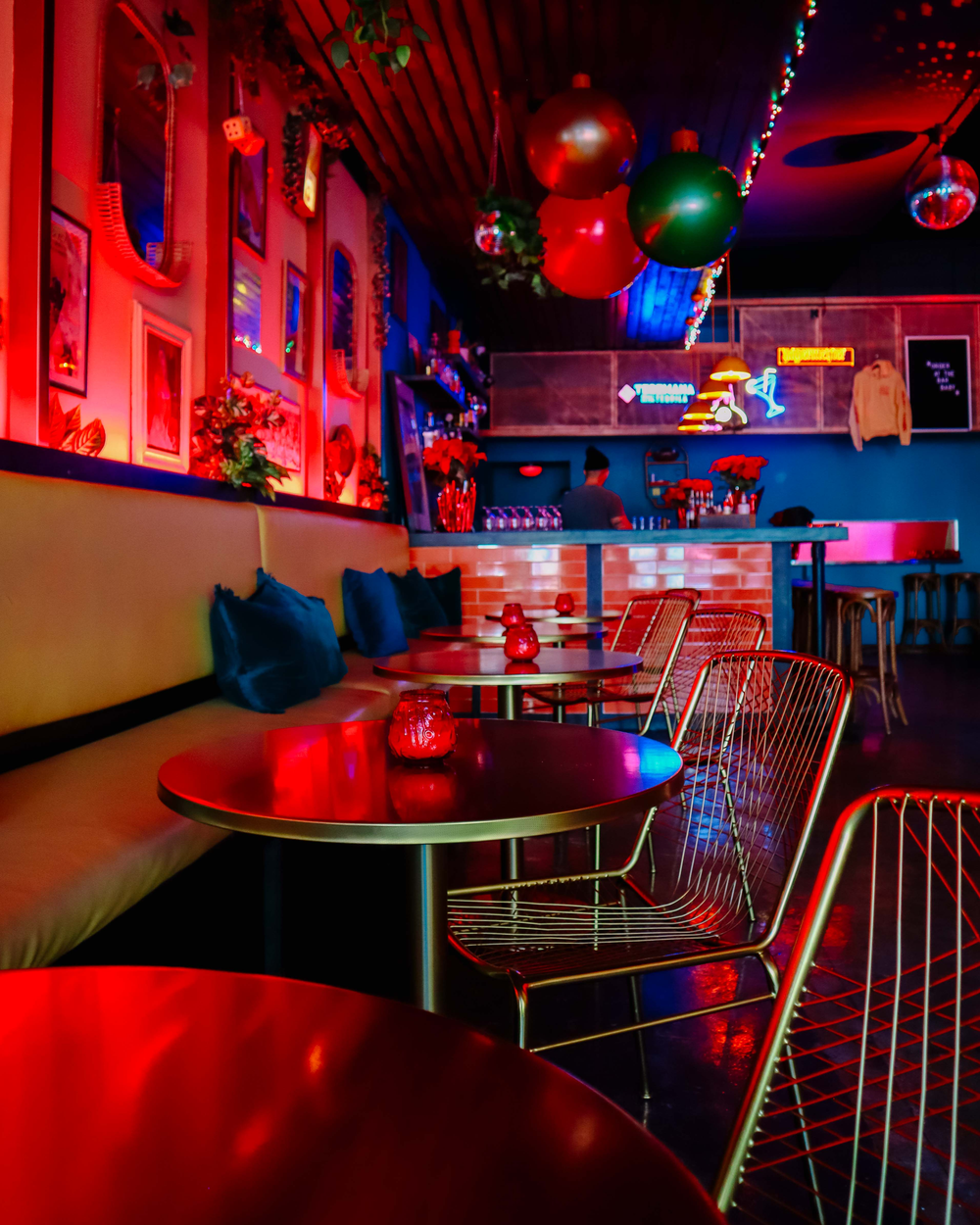 Modern lounge space decorated with colorful LED lighting and festive holiday decorations.