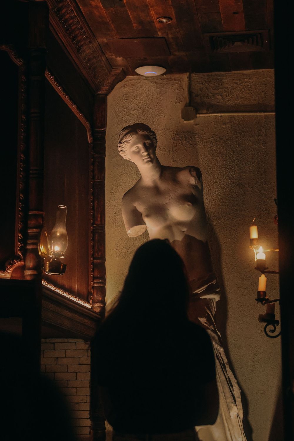 Dimly lit artistic wall installation with sculptural elements and atmospheric lighting.