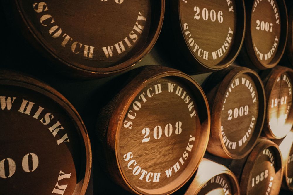 Close-up of vintage Scotch whisky barrel labels from 2006 and 2008.