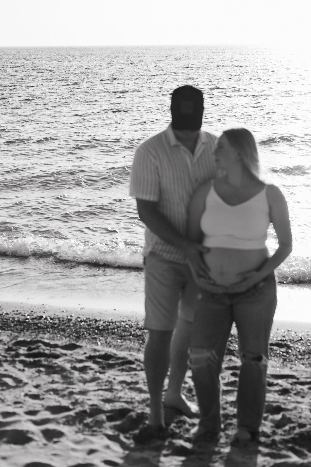 A sequence of black and white photos shows couple walking together along the beach shore at sunset.