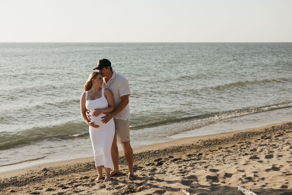 A romantic beach series showing a couple in light summer attire walking, embracing and enjoying intimate moments by the ocean.