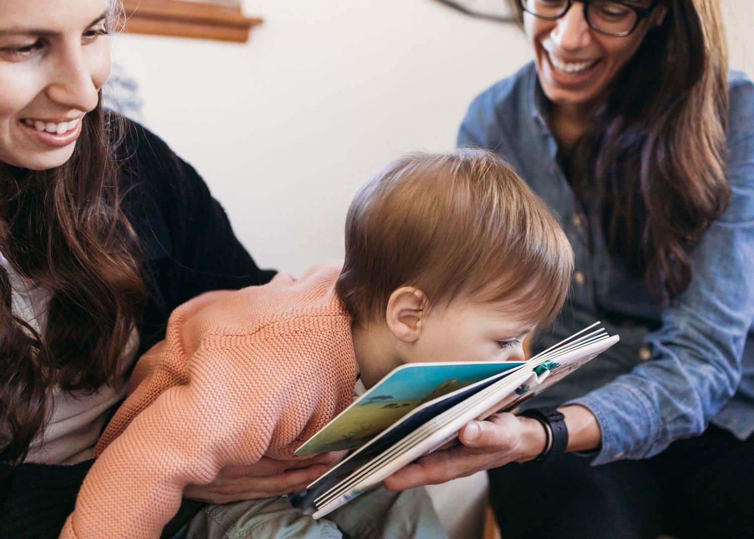 A sequence of close-up shots shows adults and children reading books together in a cozy home setting.