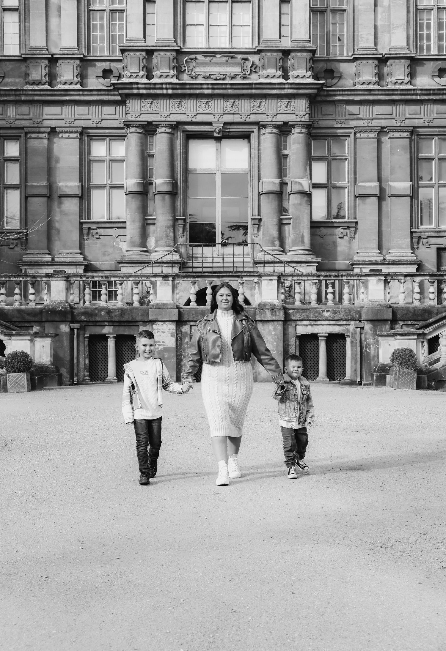 Black and white photograph of family walking outside a grand Victorian-era building, during family shoot in Nottingham