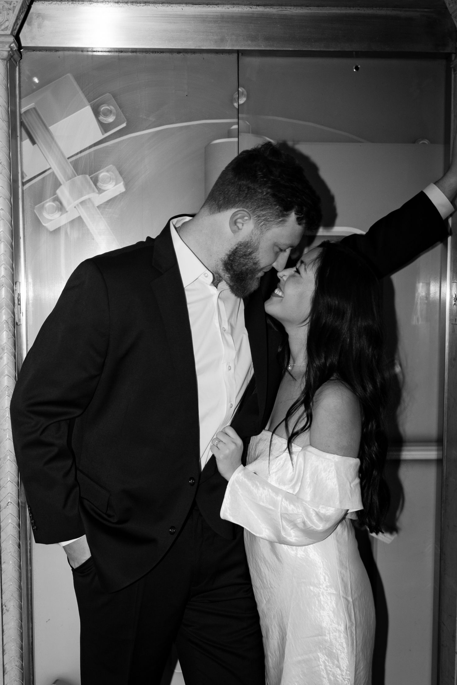 A black and white photo sequence showing silhouettes of two figures in formal wear embracing in four romantic poses.