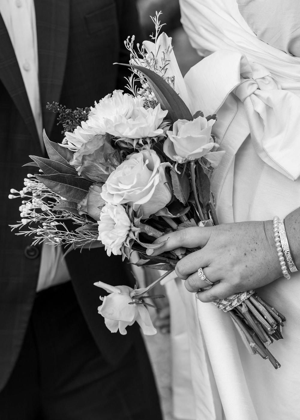 Black and white close-up of wedding bouquets with white roses and delicate flowers.