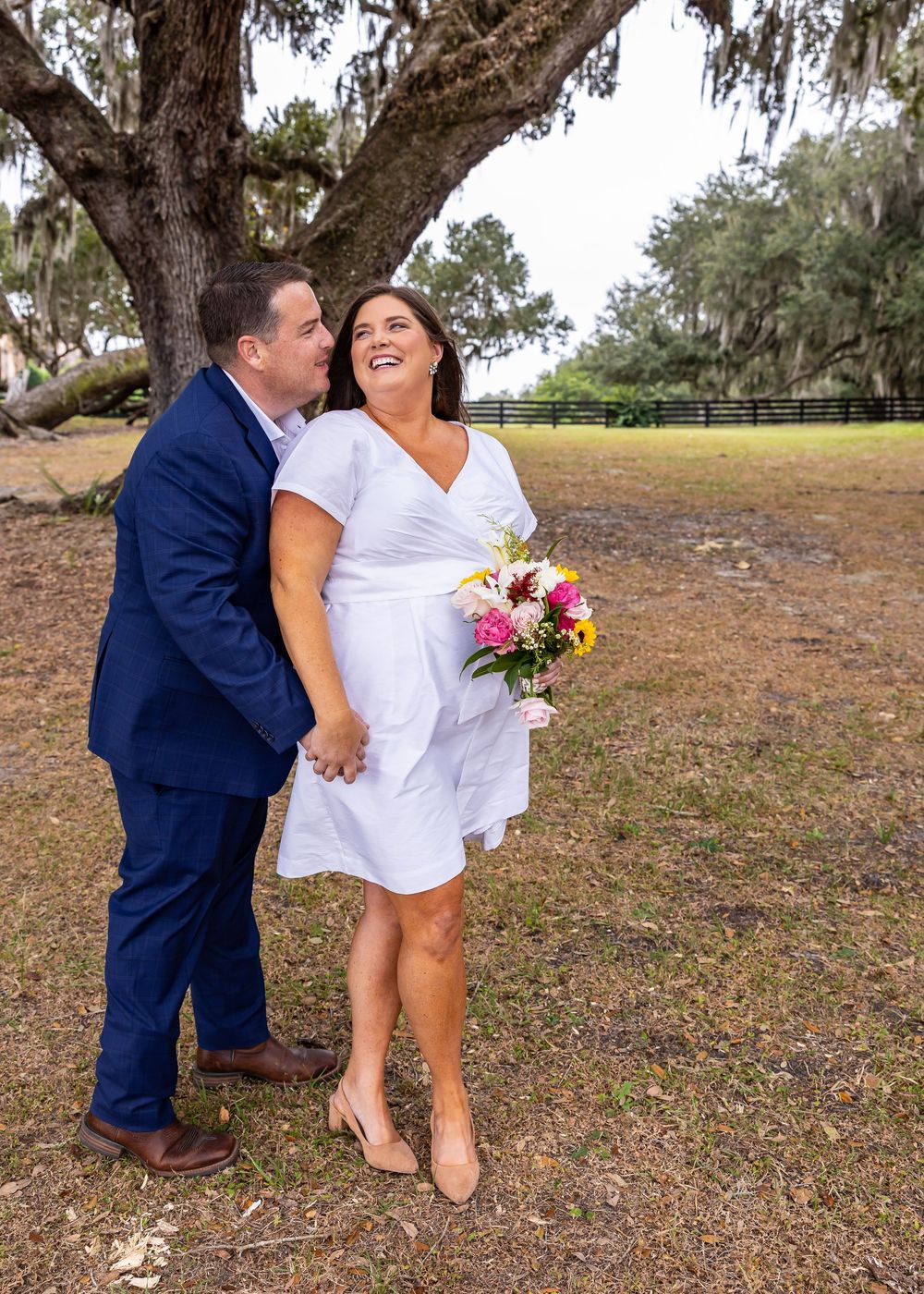 Playful outdoor wedding photos taken under large oak trees.