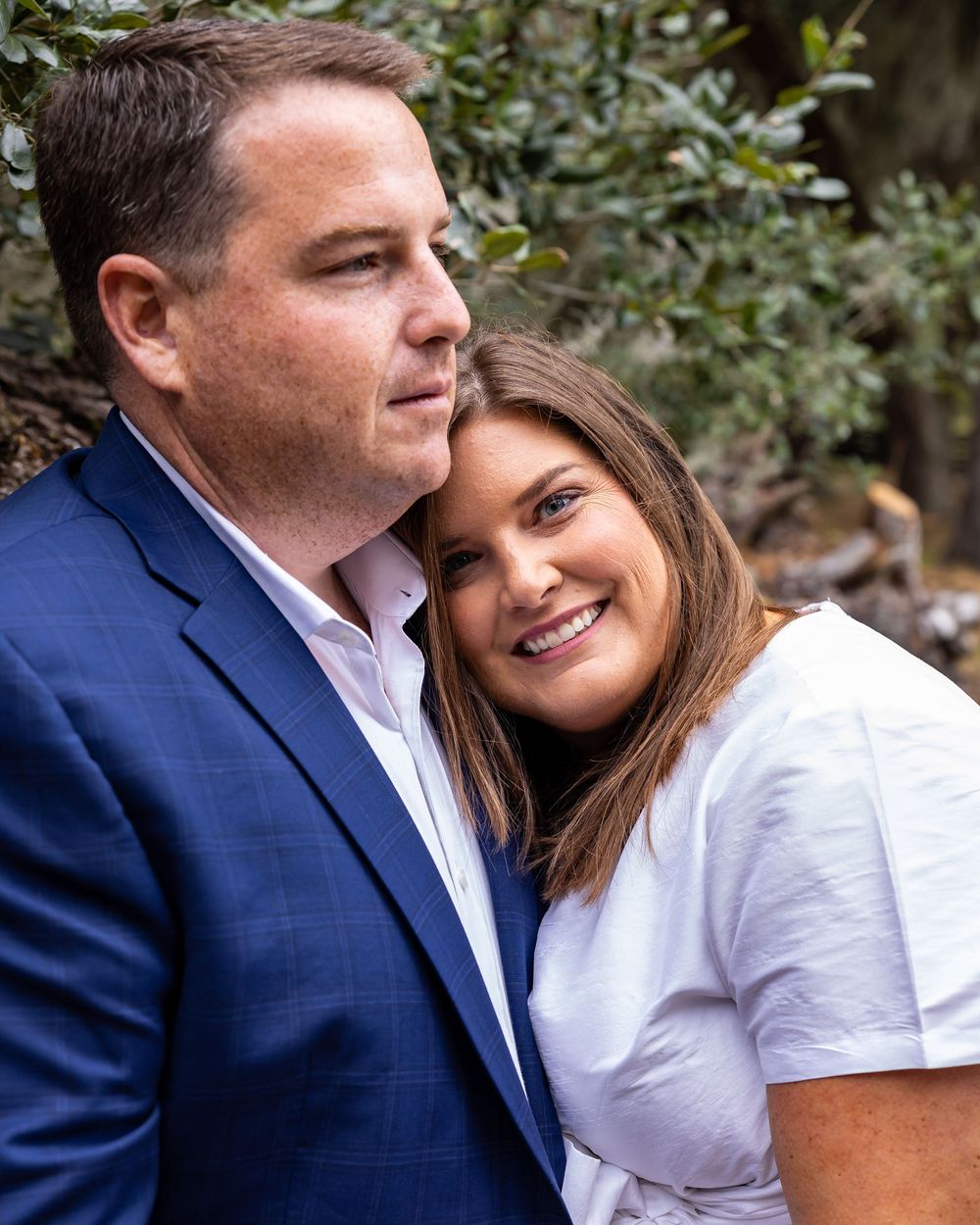 Intimate couple portrait session among green foliage and trees.