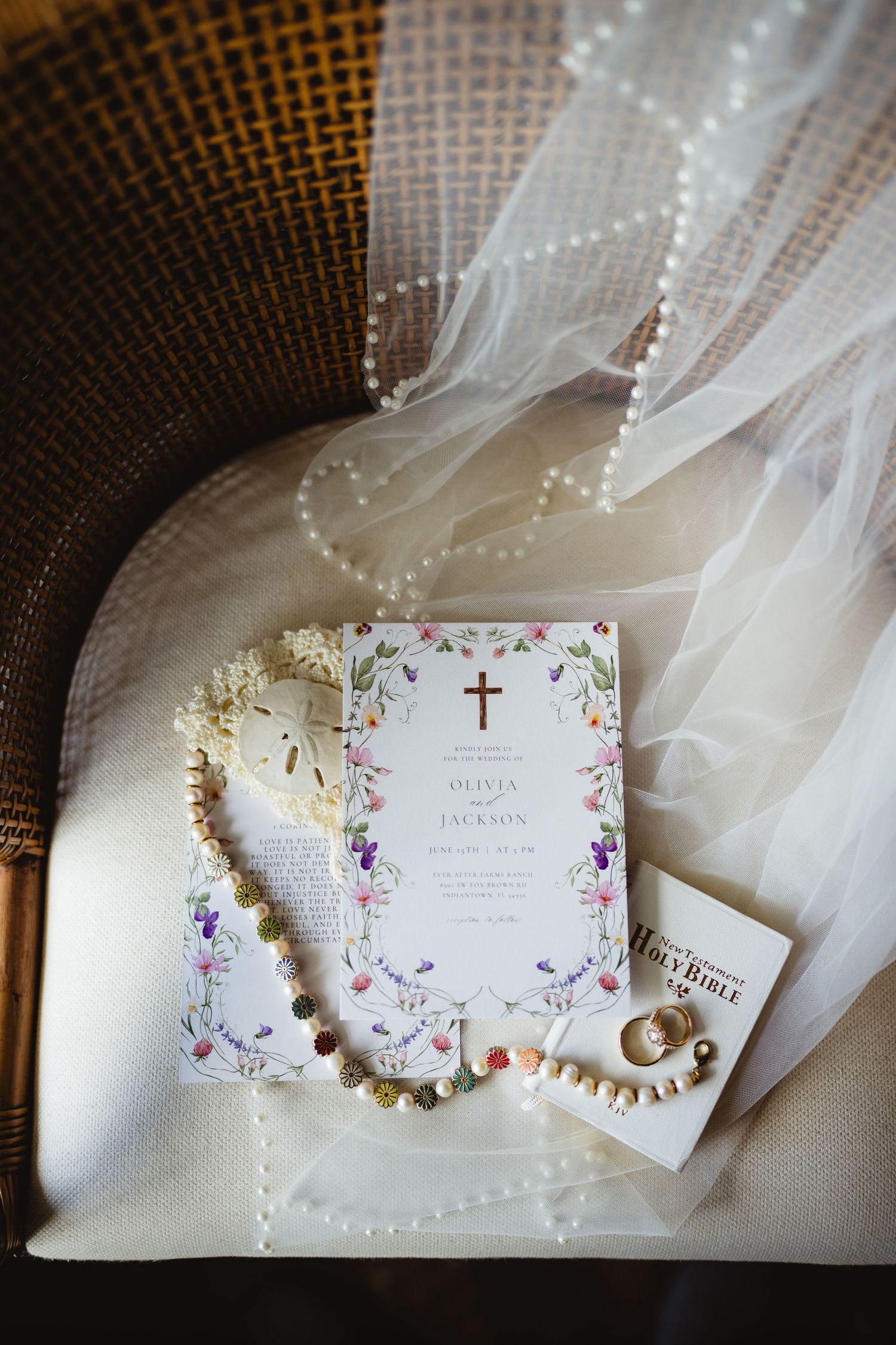 A collection of wedding stationery showing invitations and delicate veil details against a dark textured background.
