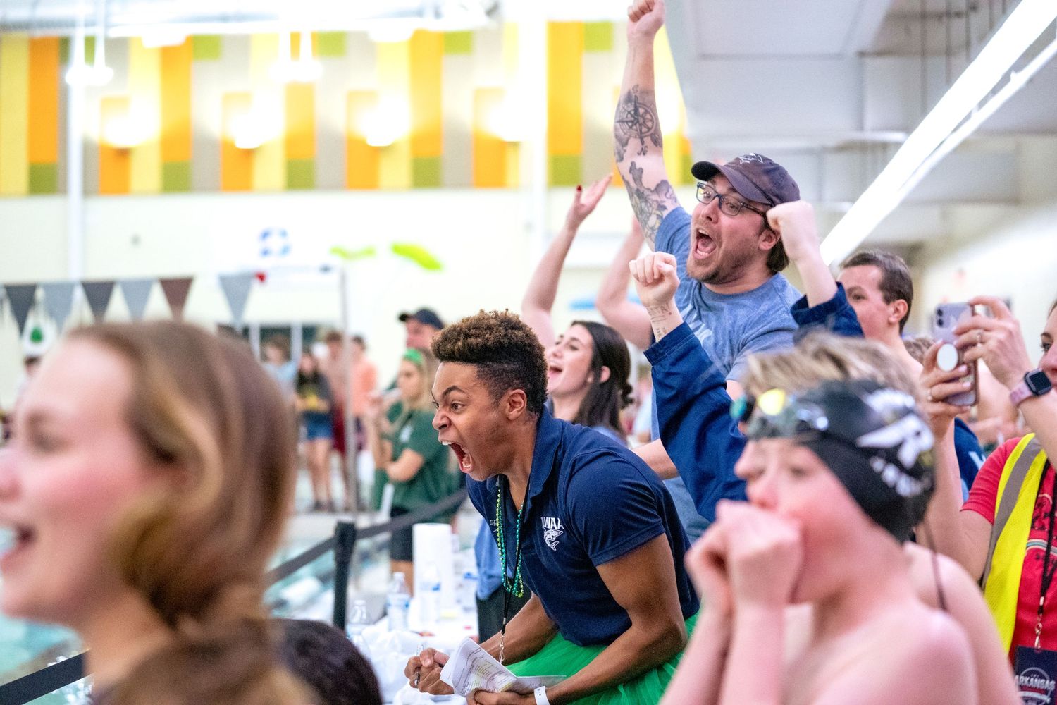 The crowd roars! People cheering jumping yelling in joy and celebration for their teammates.