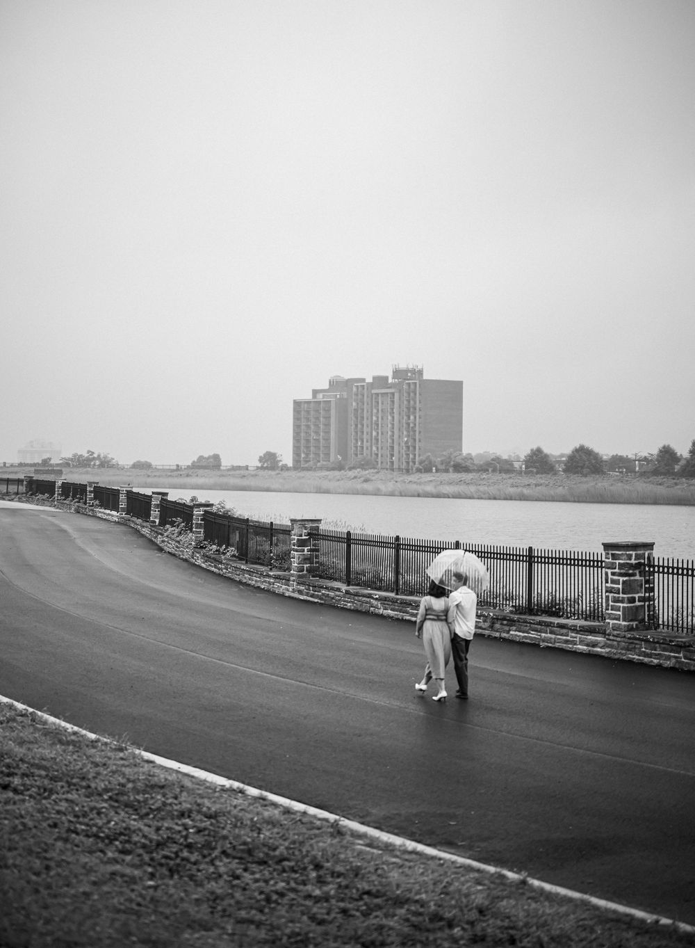 A sequence showing someone inspecting a long black line painted on a concrete surface next to a waterfront, in Baltimore