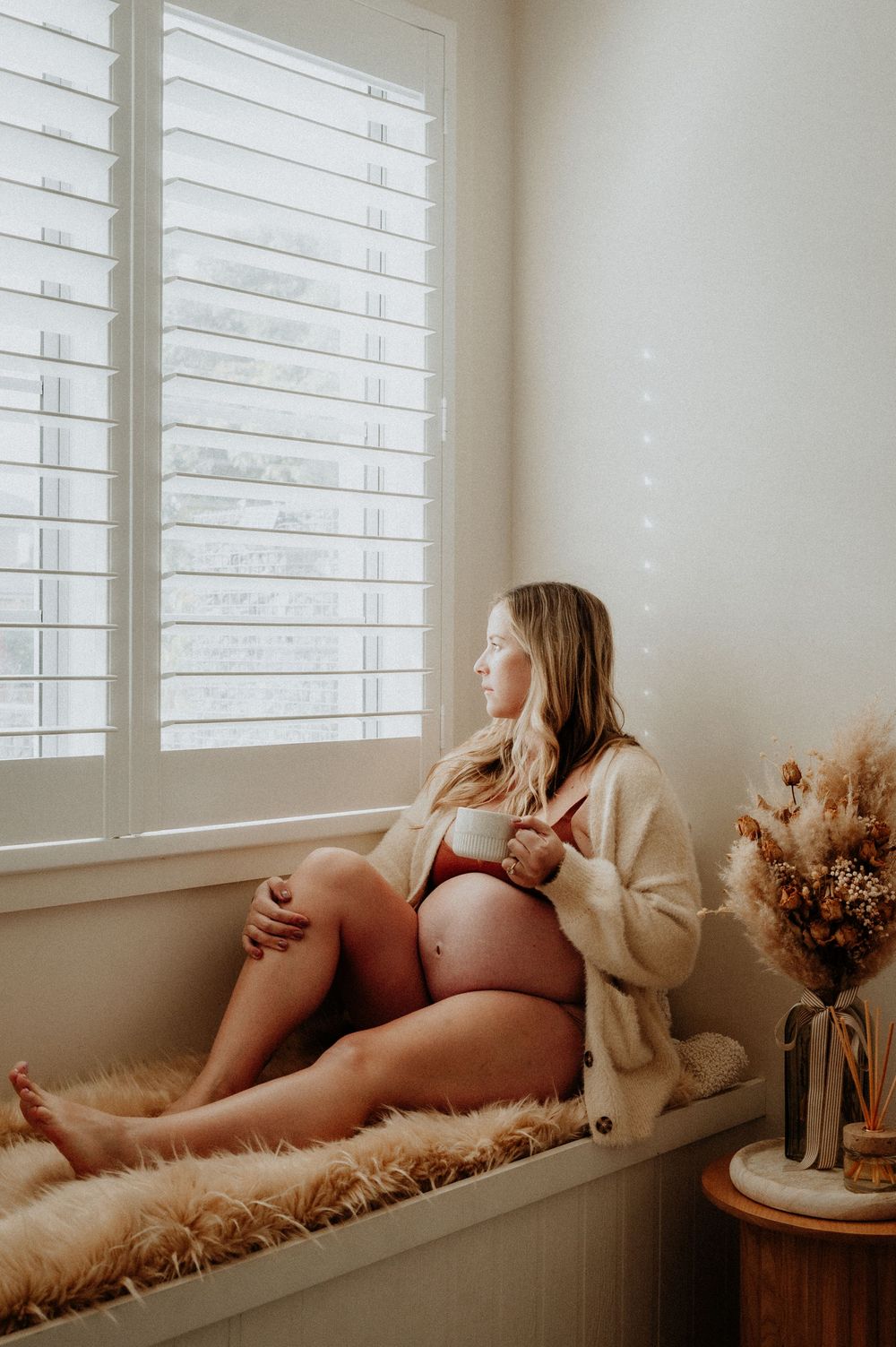 Intimate maternity portrait by window with woman relaxing on fuzzy window seat.
Altona Family Photographer Melbourne