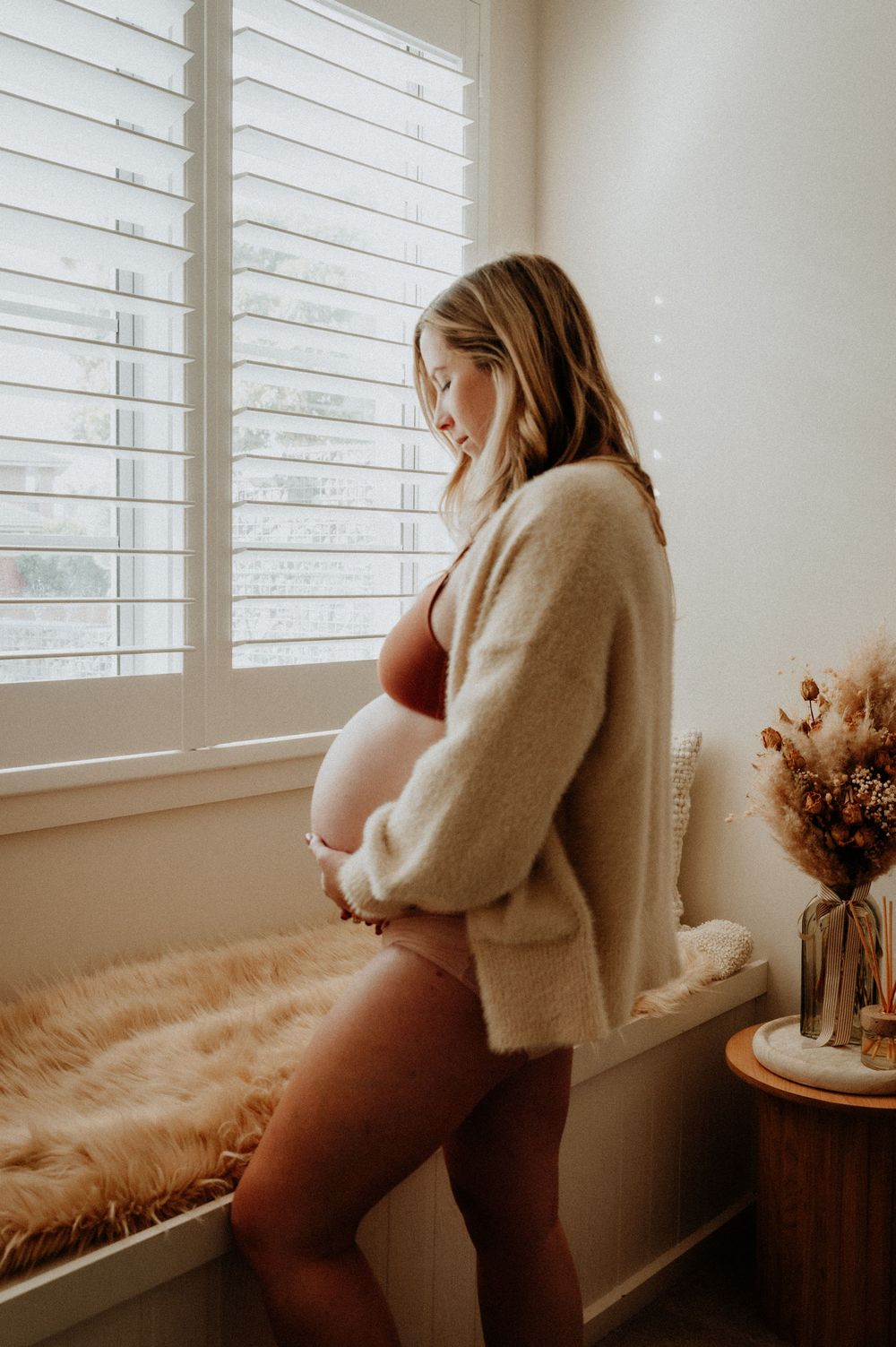 A series of soft, muted photos showing a nurturing indoor maternity scene by a window with dreamy natural light.
Altona Family Photography