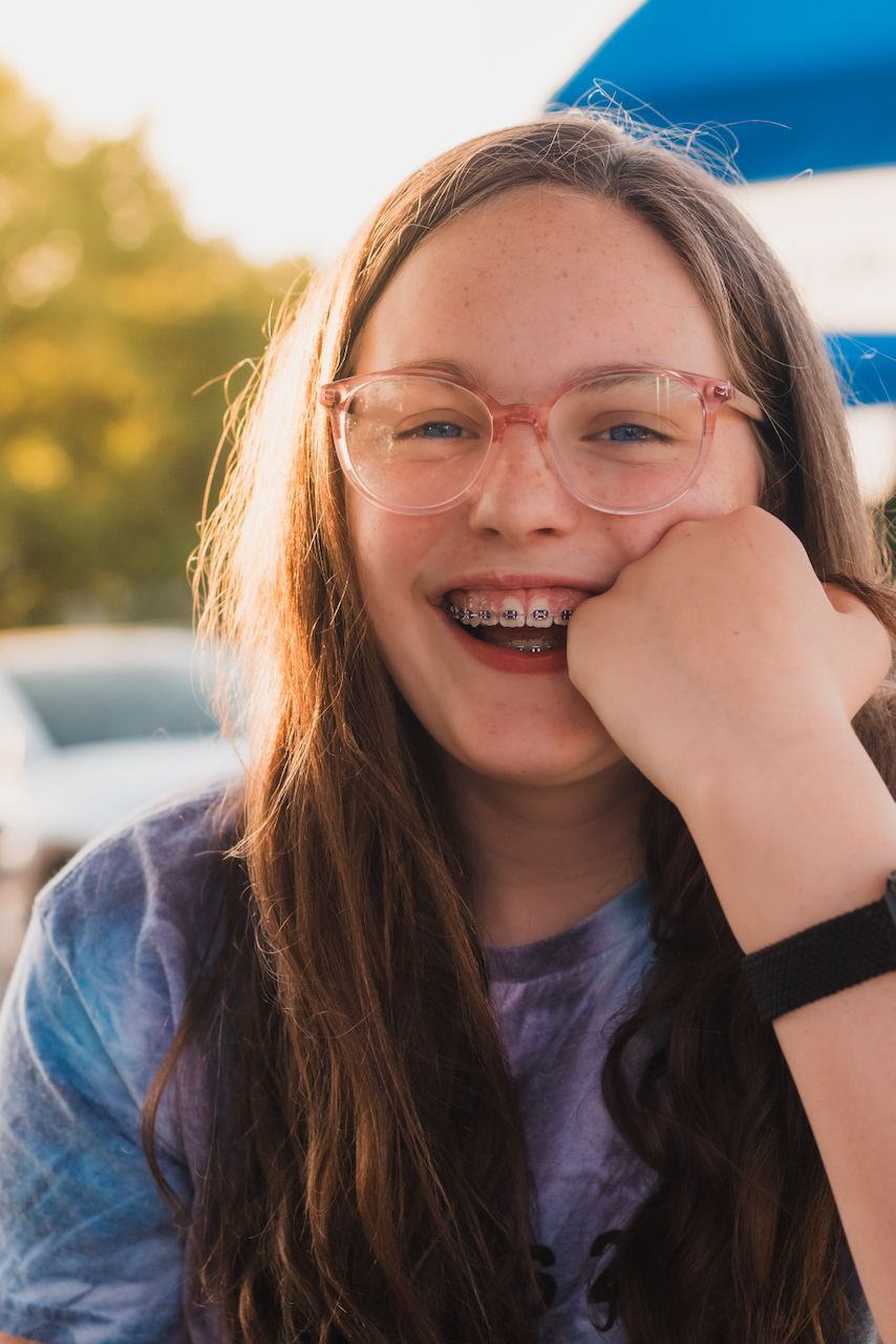 Girl with glasses smiling during golden hour - Lifestyle Family Photographer near Brighton, Michigan.