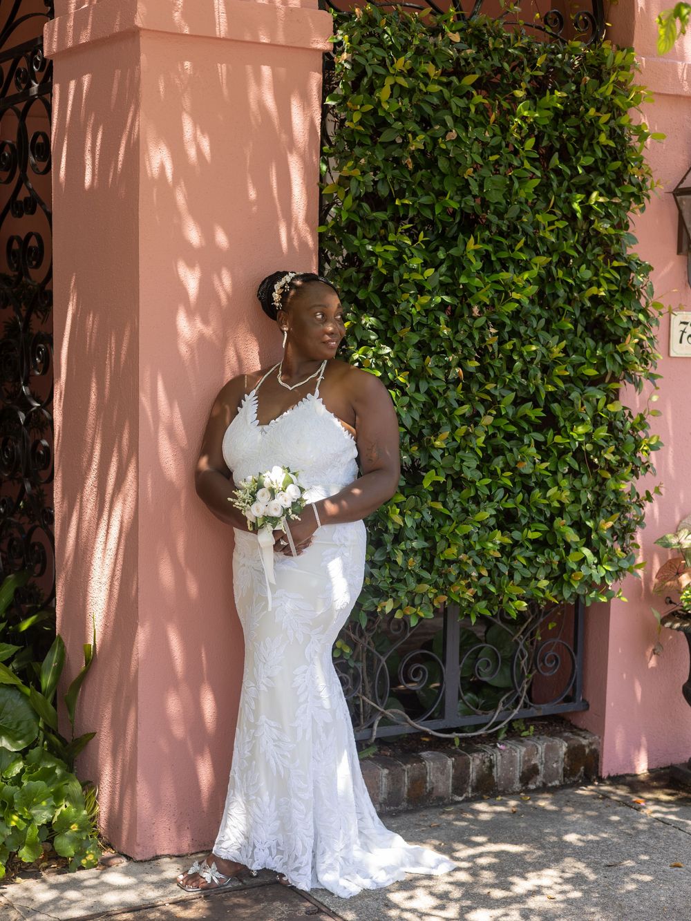 A sequence of bridal portraits against a pink stucco wall with ornate ironwork and climbing vines.