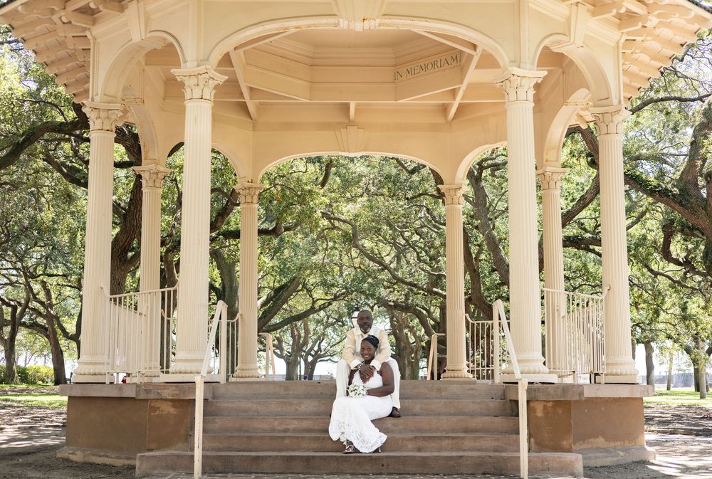 Historic sandstone colonnade with arched walkway and pillars in a garden setting creates an elegant architectural perspective.