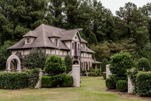A series of exterior views showing a large brick and stone country house with dormer windows and landscaped grounds.
