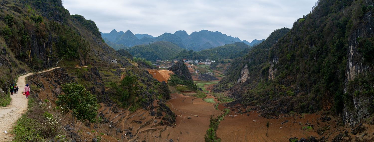 Panoramic view of a winding mountain road through a dramatic valley landscape.