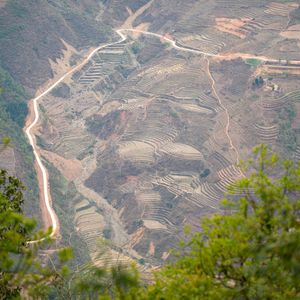 Aerial view of terraced mountainside with winding roads cutting through the terrain.