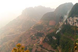 Aerial view of winding mountain roads and rugged terrain during golden hour.