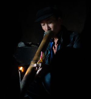 Low-light photograph showing someone lighting something in darkness.