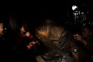 Dark interior scene with minimal lighting and scattered illuminated objects.