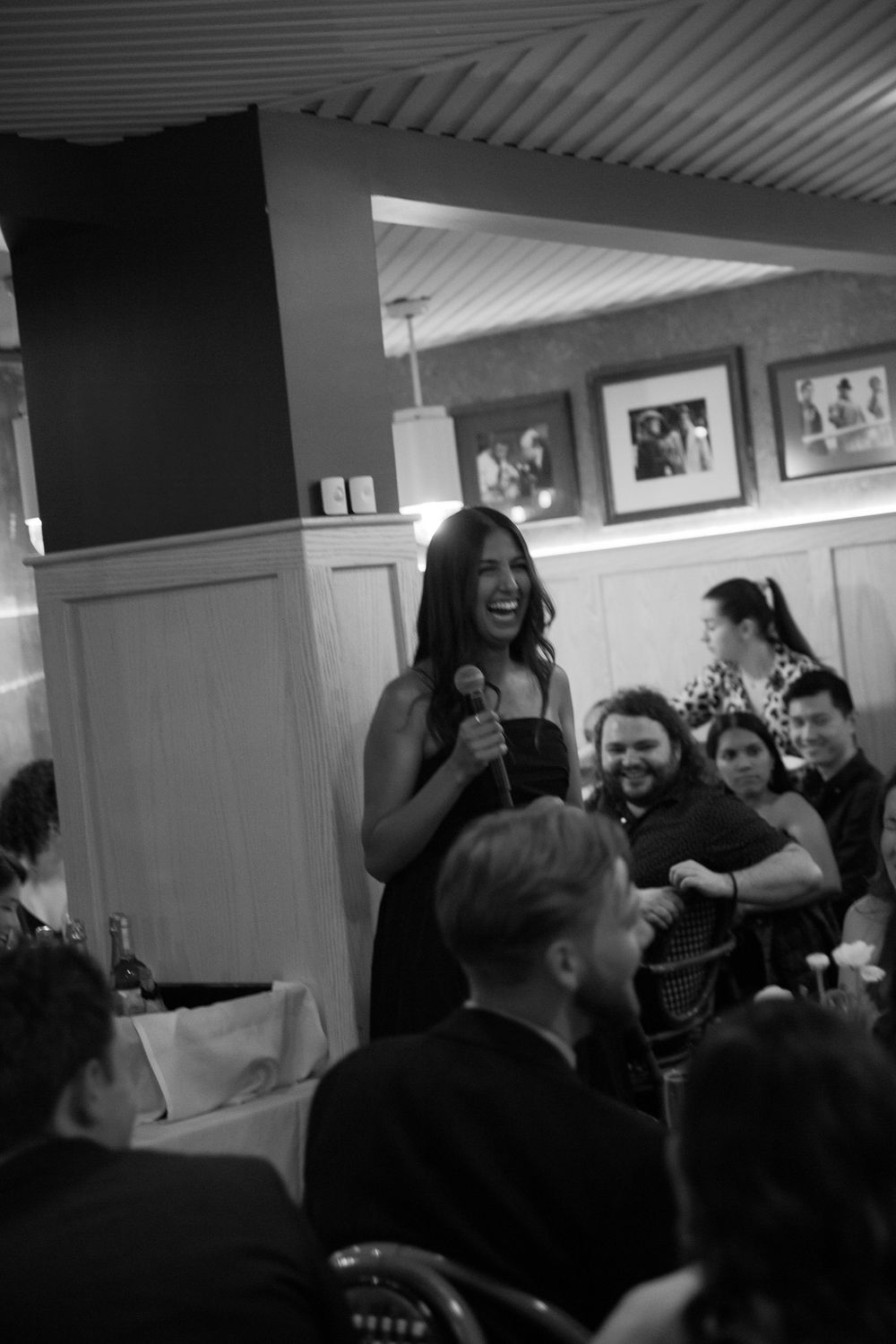 Crowd laughing and enjoying themselves at an indoor celebration.