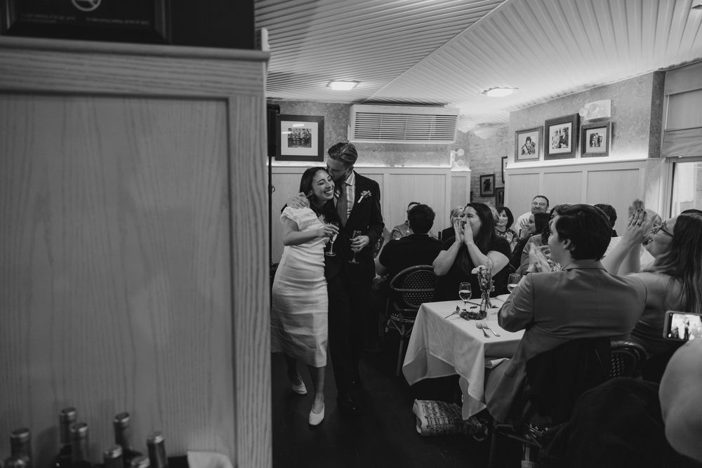 Wedding guests gather and mingle in an indoor reception space.