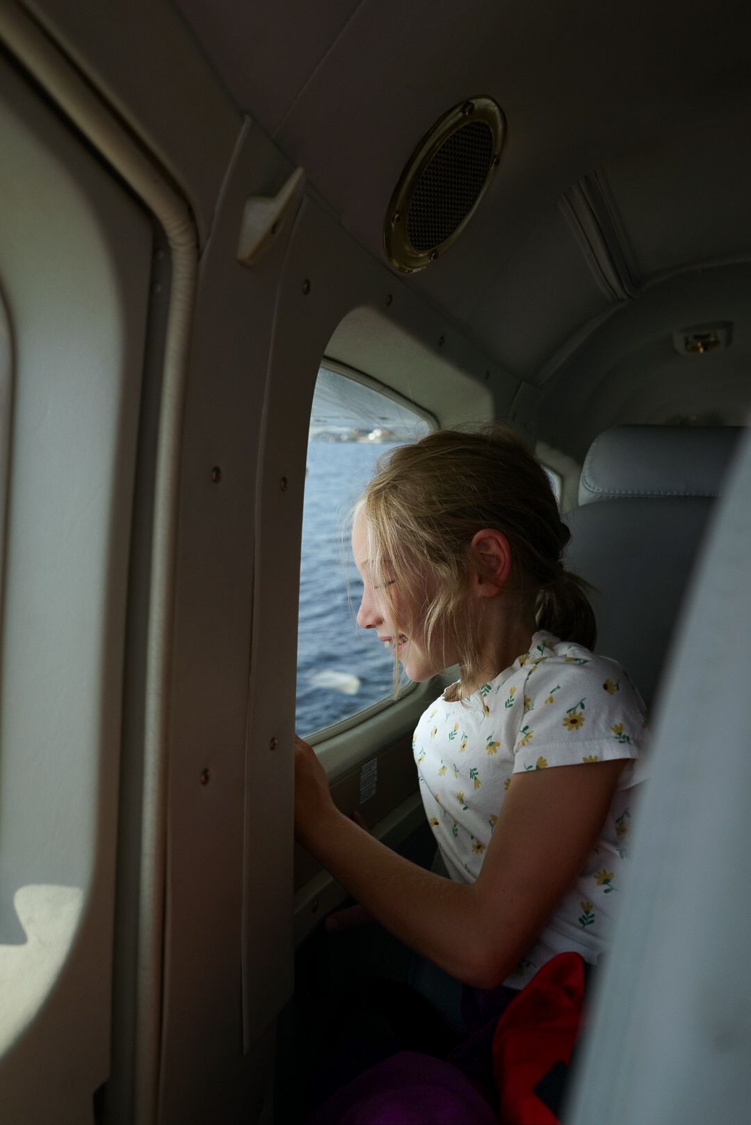 Inside view of a small aircraft cabin during flight over water.